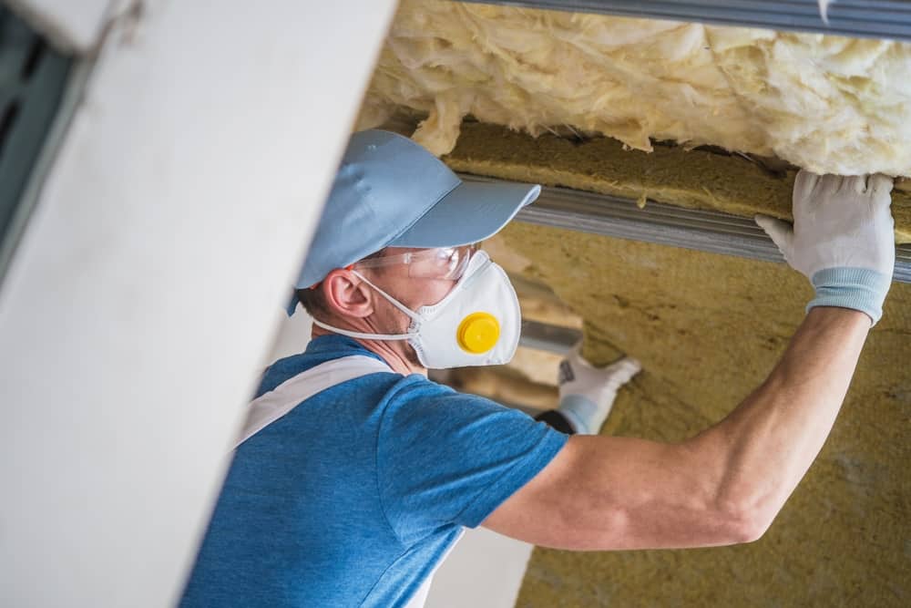 Worker installing attic insulation